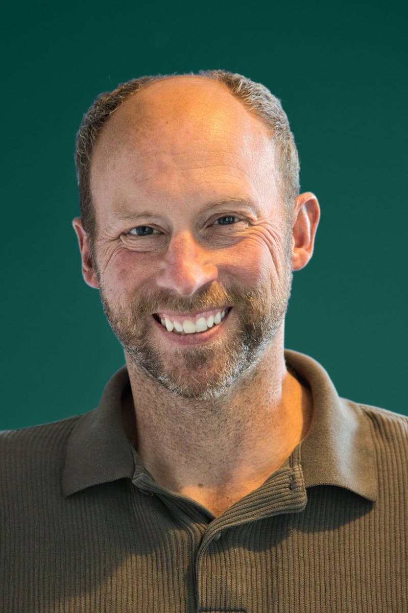 Rob Parker-Cole, smiling, against a dark green background